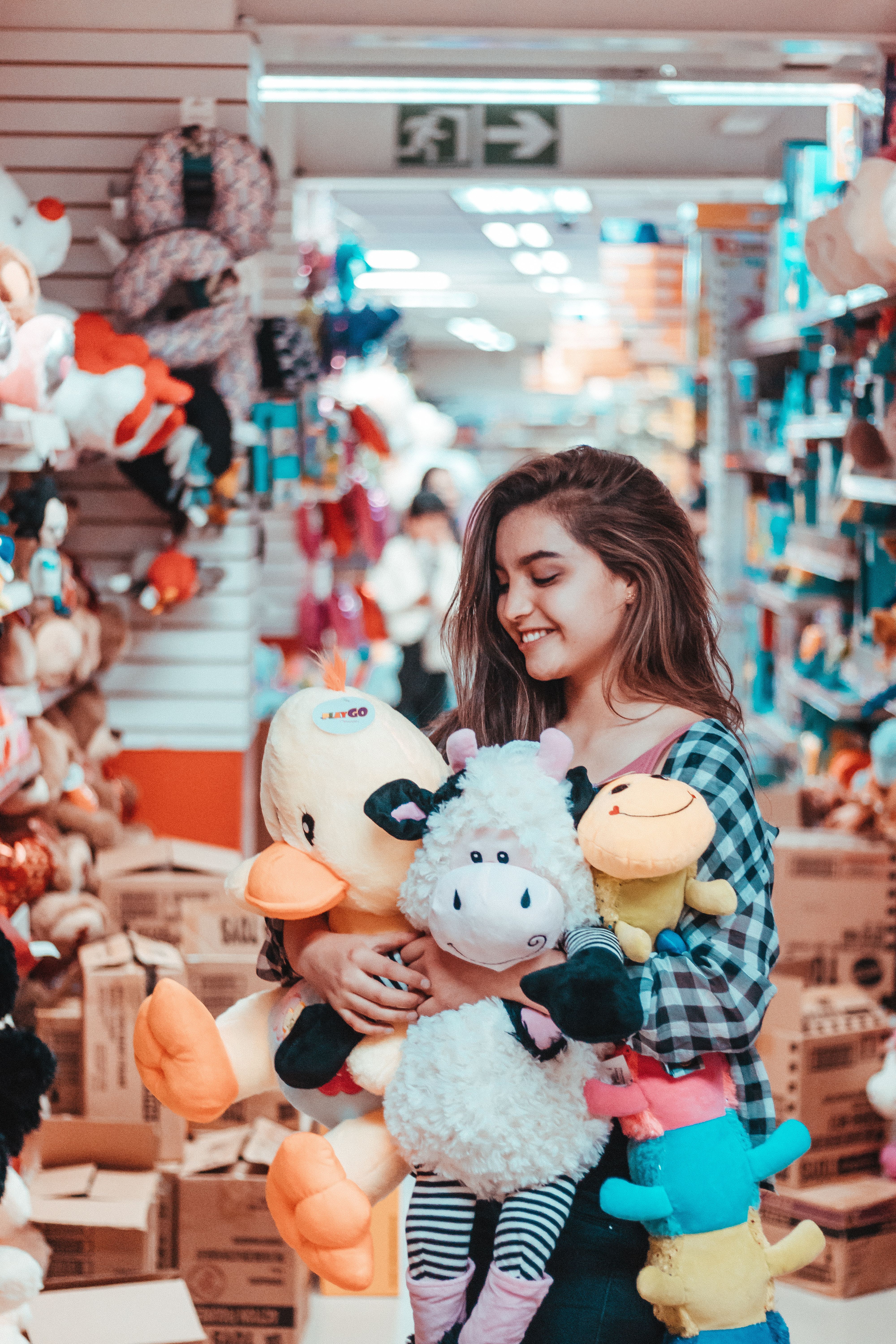 Happy Girl in Toy Store Holding Multiple Quality Plush Toys - Shopping for Best Stuffed Animals